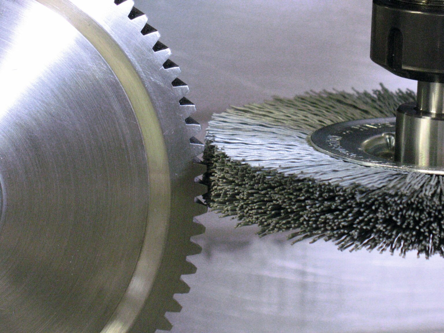 A gear is deburred with a wheel brush with shank