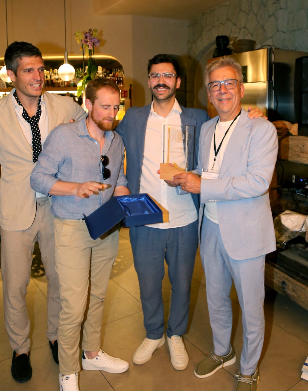 Jürgen (right) and Johannes Lessmann (second from right) receive the trophy for first place in the 2025 Innovation Award.